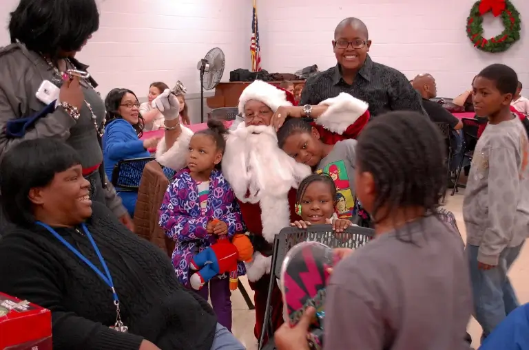 Children gathered around Santa at a past CYD holiday toy giveaway